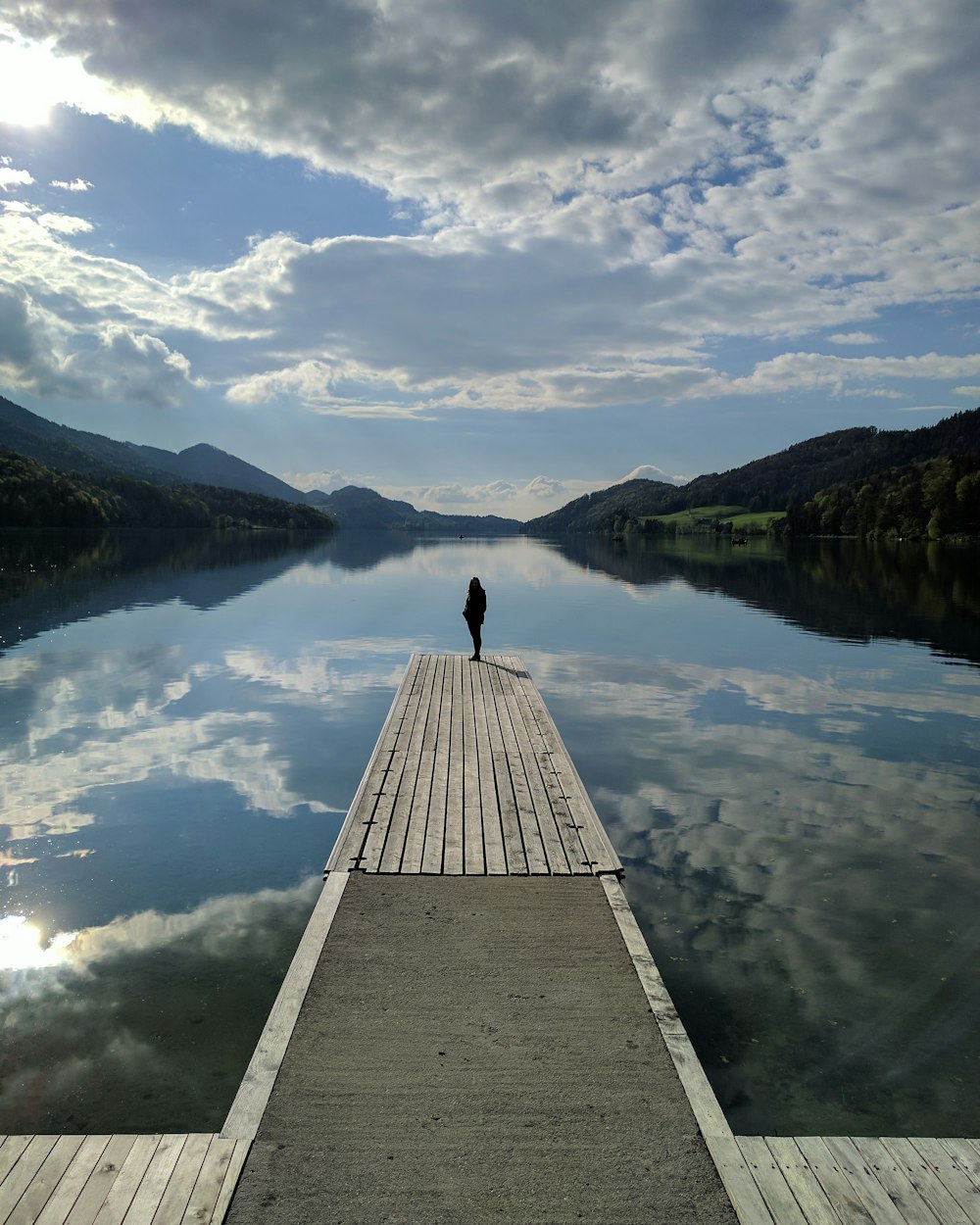 a person standing on a dock looking at the water