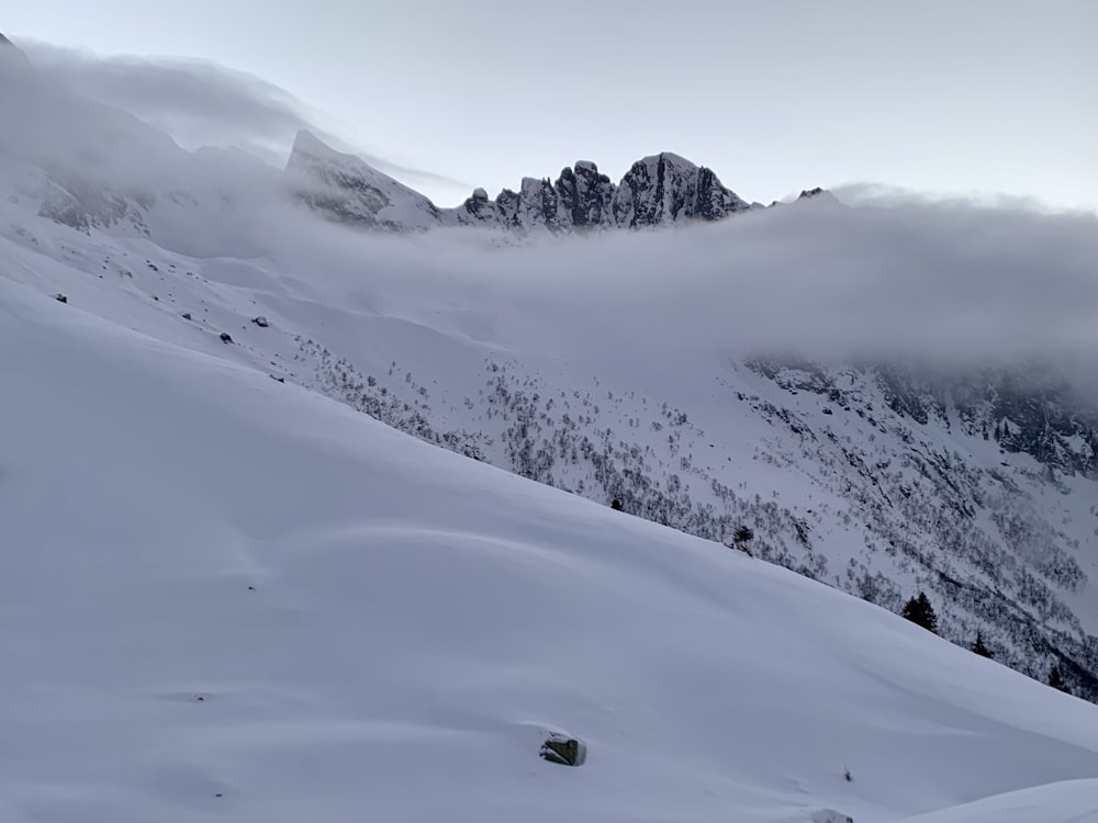 a mountain covered in snow with a few clouds