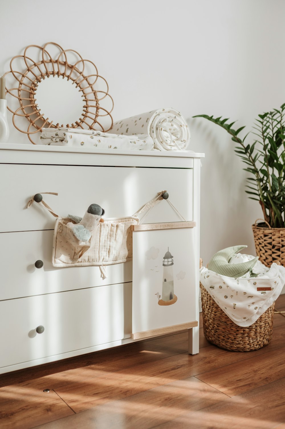 a white dresser with a basket on top of it