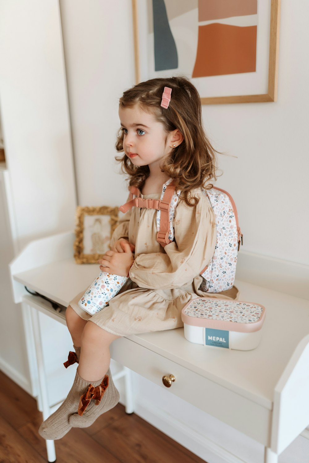 uma menina sentada em cima de uma mesa branca