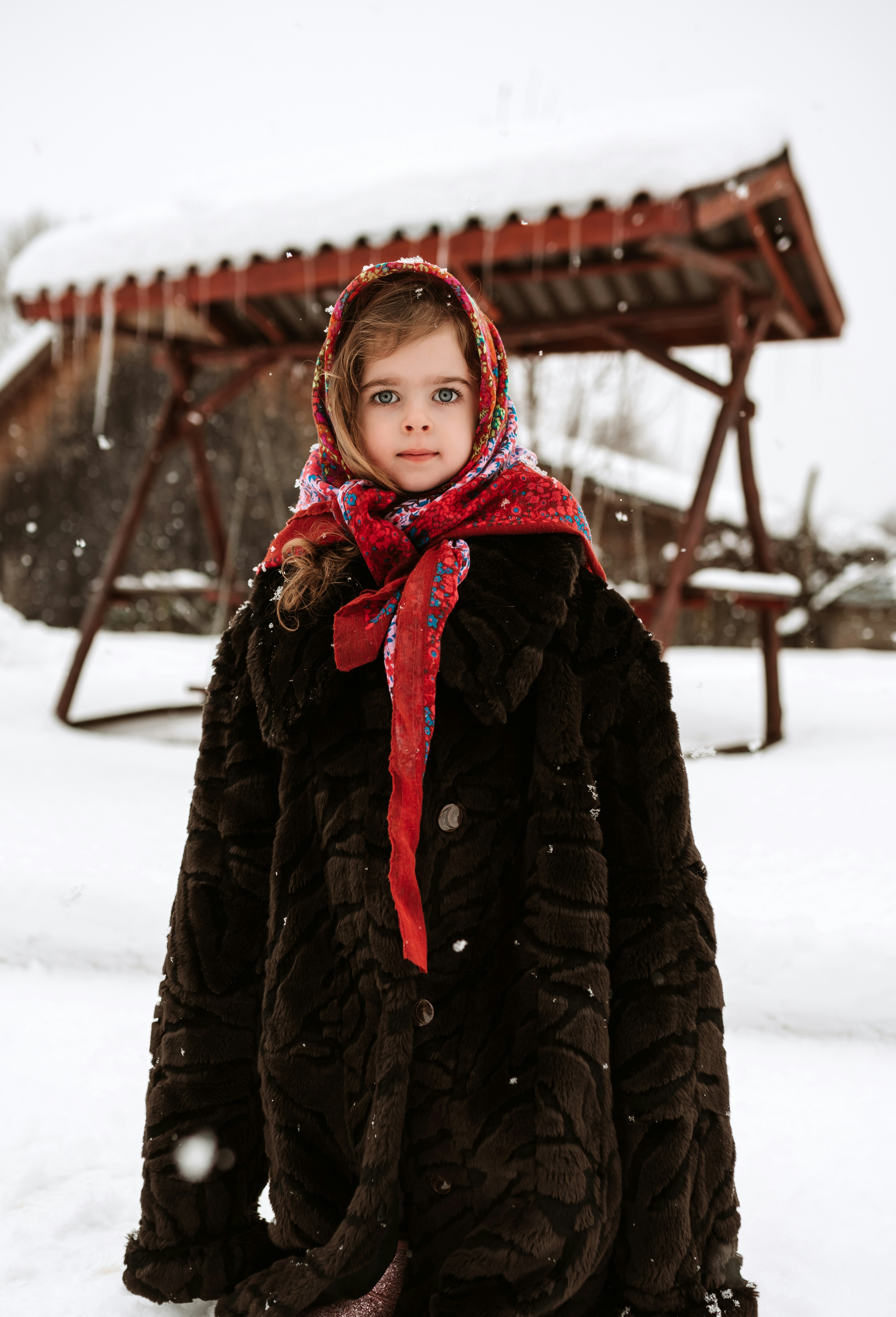 A little girl standing in the snow wearing a coat and scarf photo ...