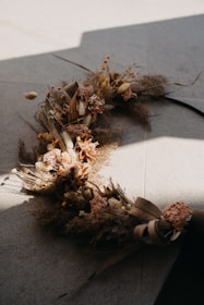 Artistic floral installation featuring muted sage and soft clay hues.