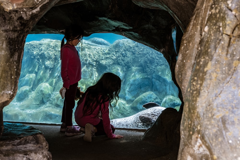 a couple of kids that are standing in a cave