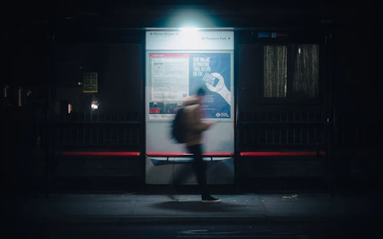 a person standing in front of a bus stop at night