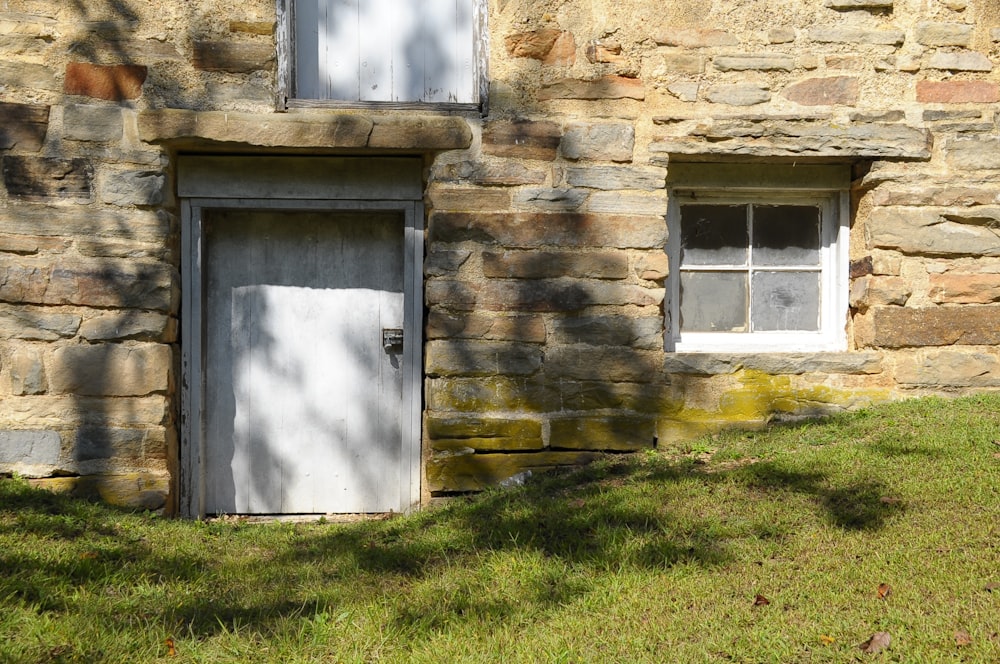 a stone building with a white door and window