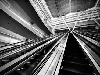 High-contrast black and white photograph of a fashion runway with bold, angular lighting.