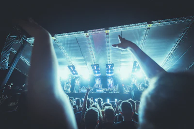 A lively crowd applauding a theatrical performance under warm evening lights