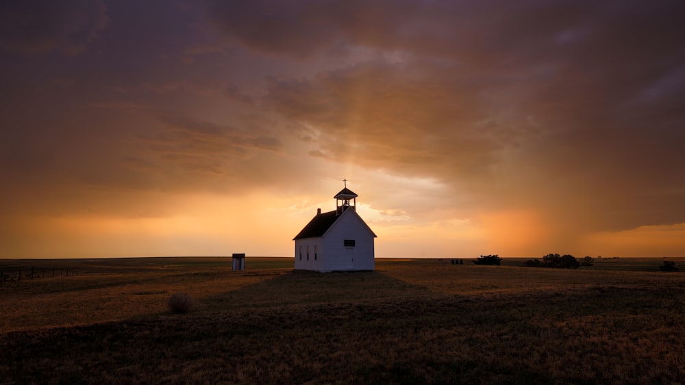 Une maison avec un coucher de soleil en arrière-plan