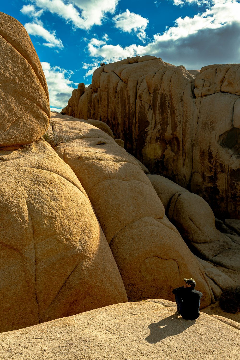 a person sitting on top of a large rock formation