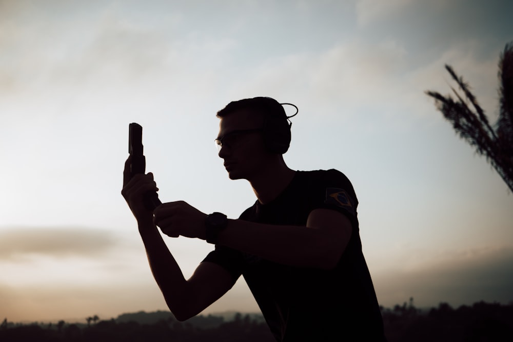 a silhouette of a man holding a cell phone