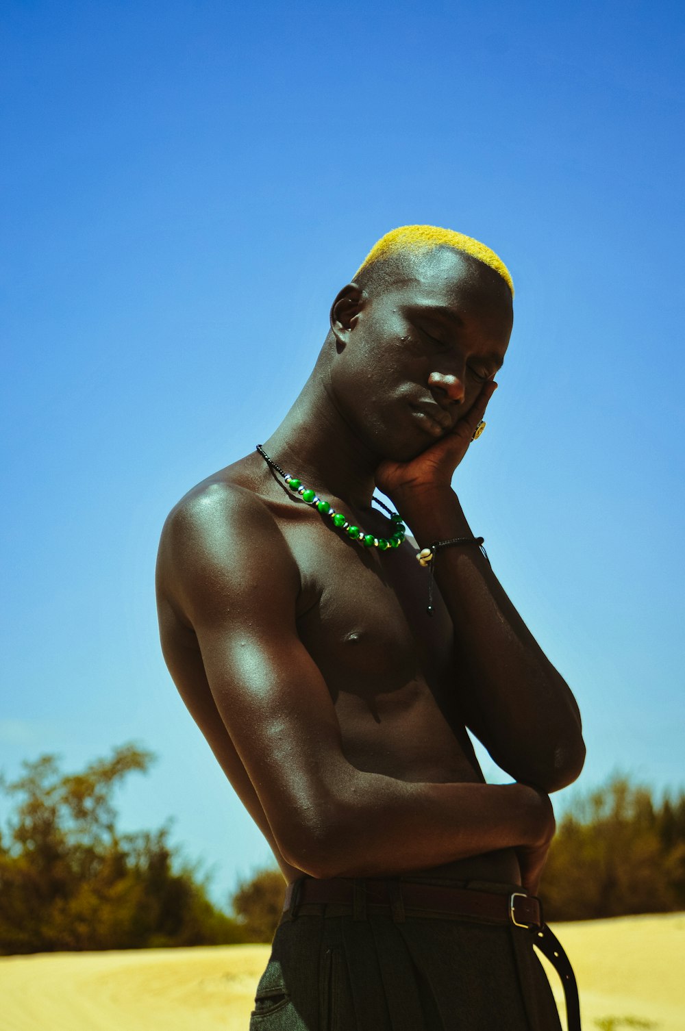 Un homme avec un bandeau jaune debout dans le sable