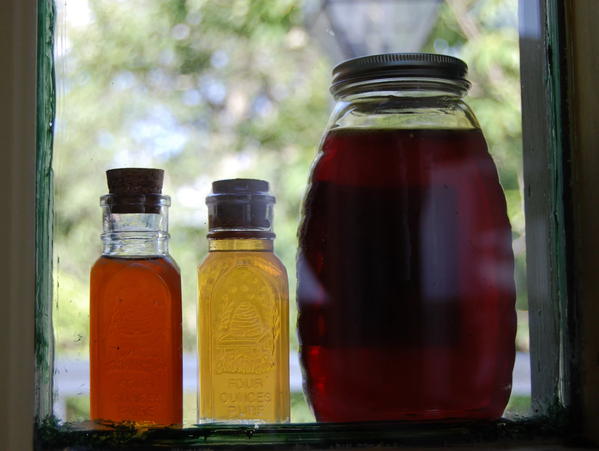 Various colors of honey on a windowsill