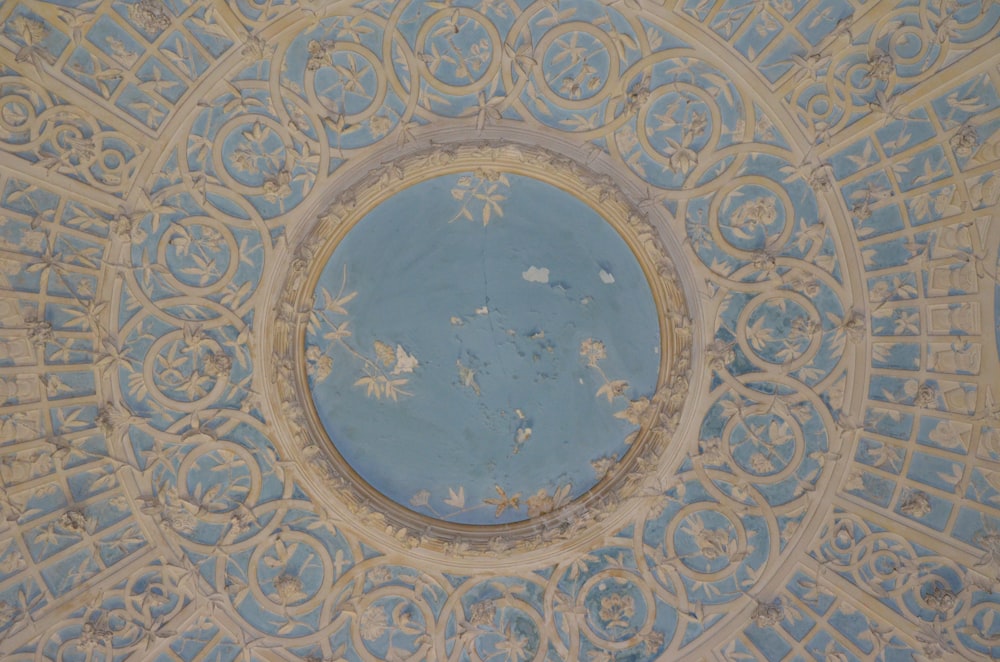 a blue and white ceiling with a circular window