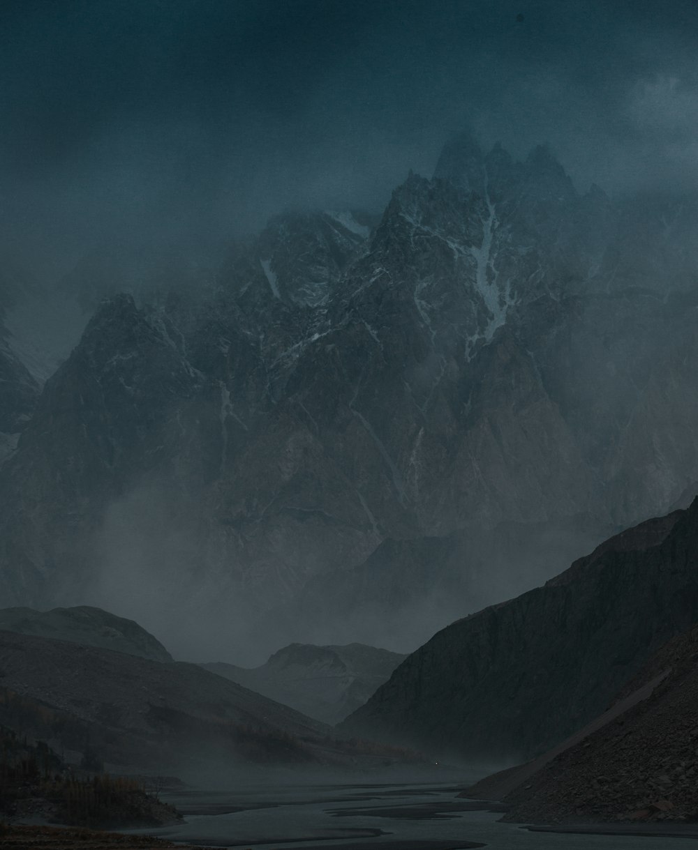 a mountain range with a river in the foreground