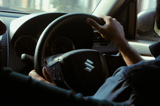 a man driving a car with a steering wheel
