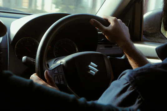 a man driving a car with a steering wheel