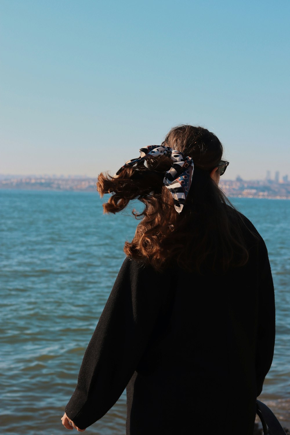 a woman standing on a beach next to the ocean