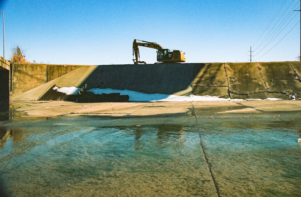 a bulldozer is parked on top of a concrete wall