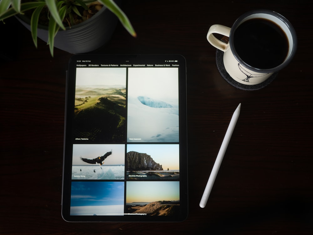 a tablet computer sitting on top of a table next to a cup of coffee