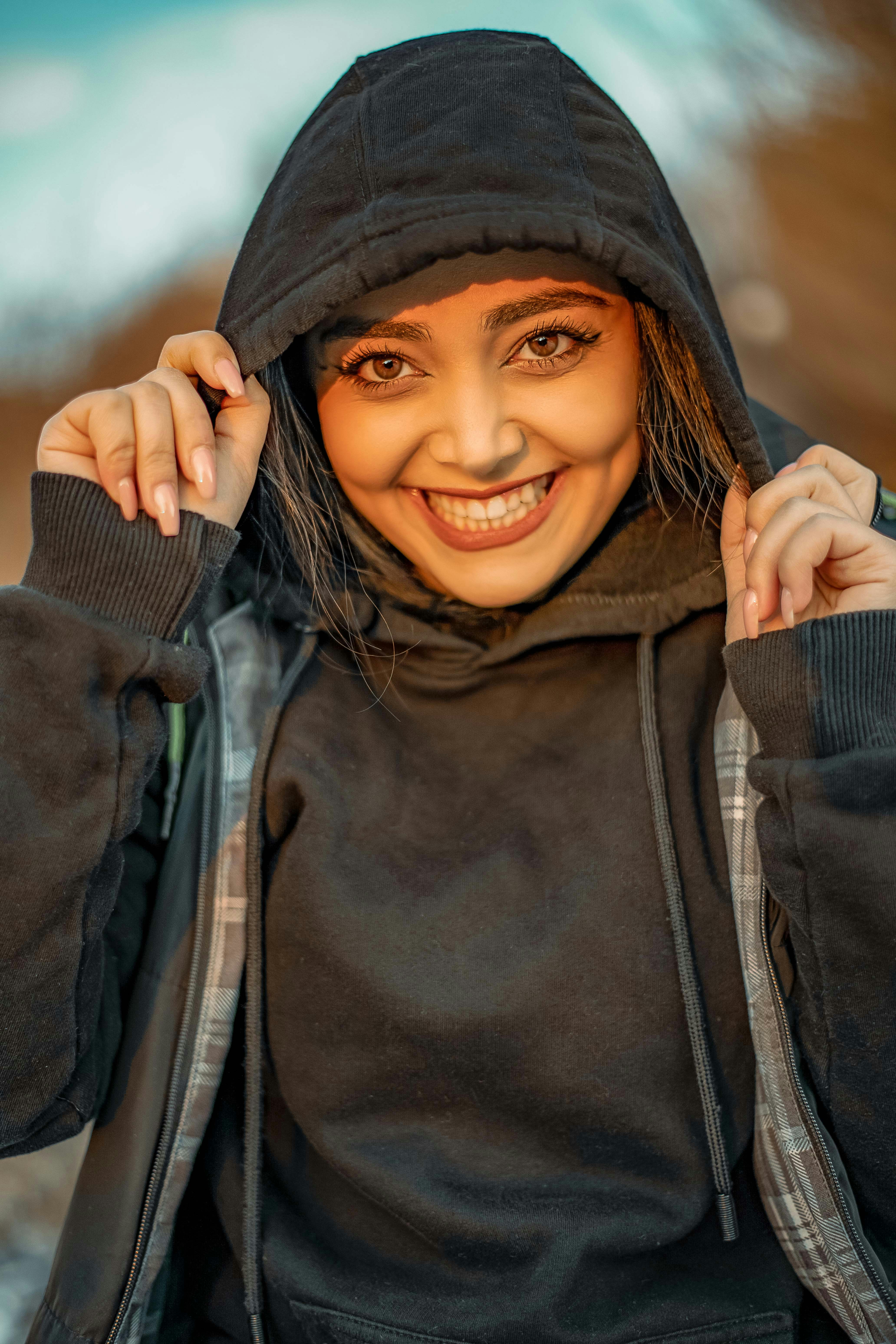 a woman in a black hoodie is smiling