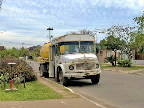 A clean, well-maintained septic pumping truck parked at a residential property on a sunny day