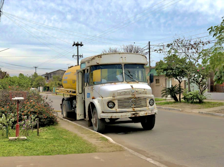 Vacuum truck cleaning a septic tank in a suburban area during daytime.
