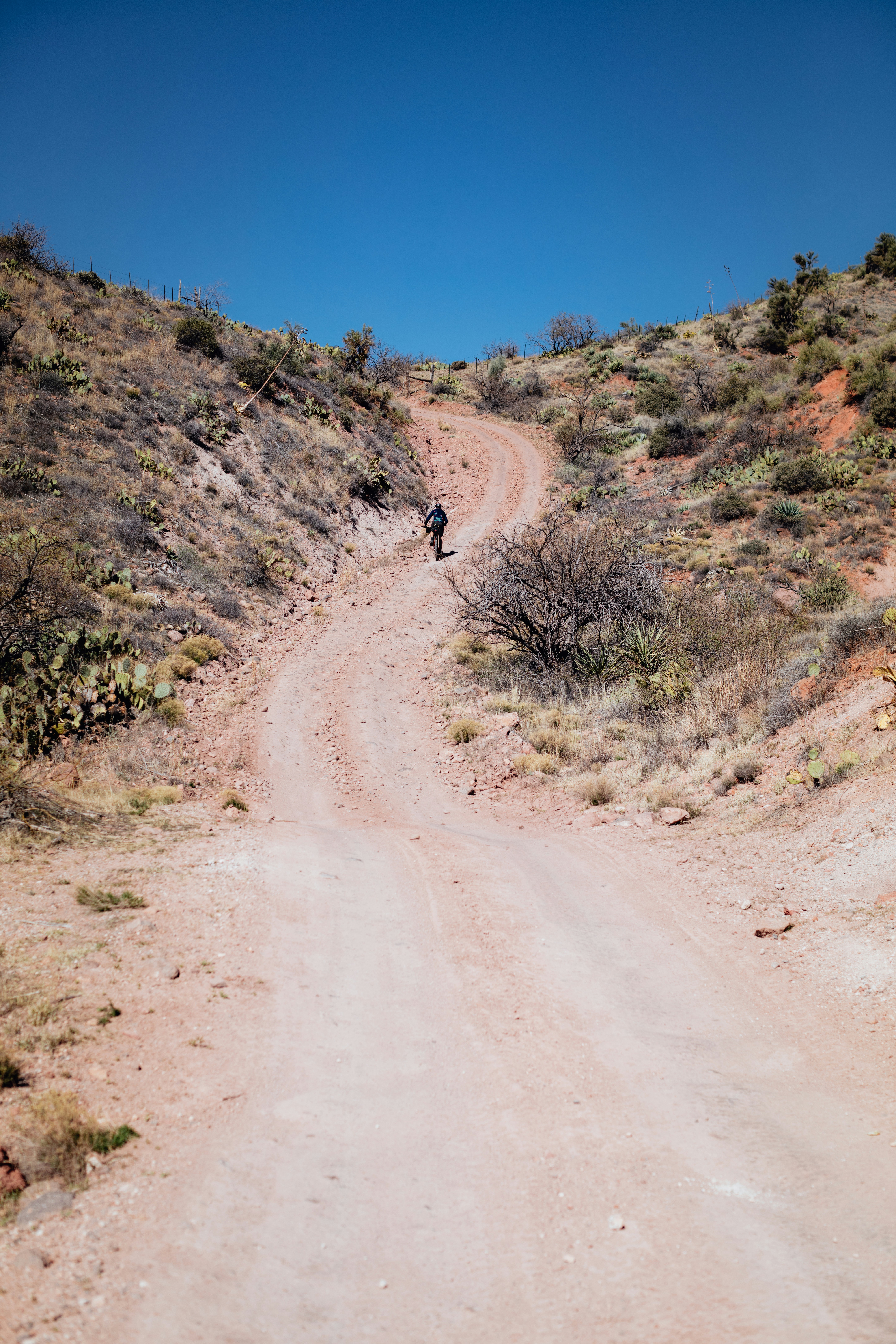 a person riding a motorcycle down a dirt road