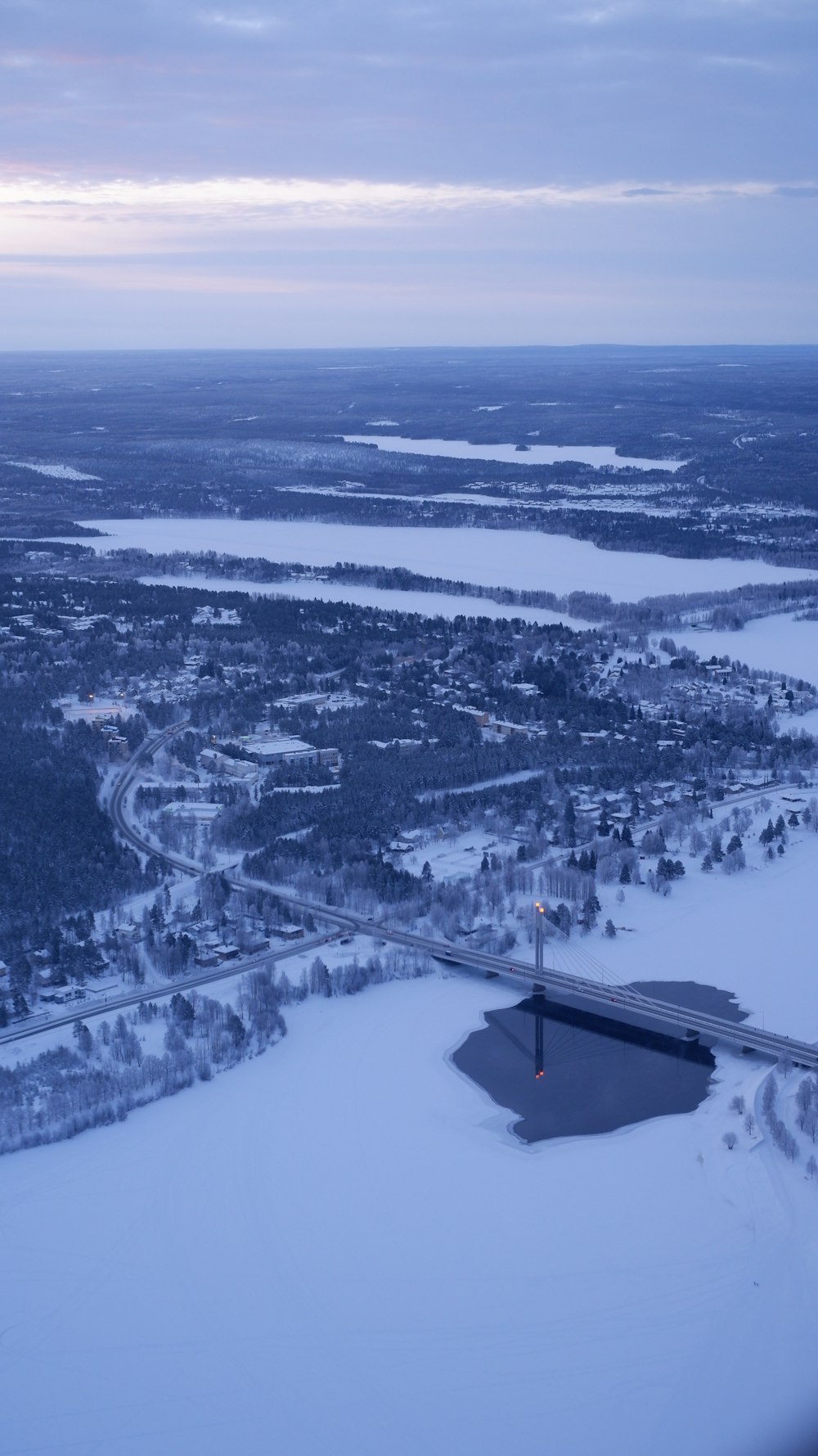 an aerial view of a city and a lake covered in snow