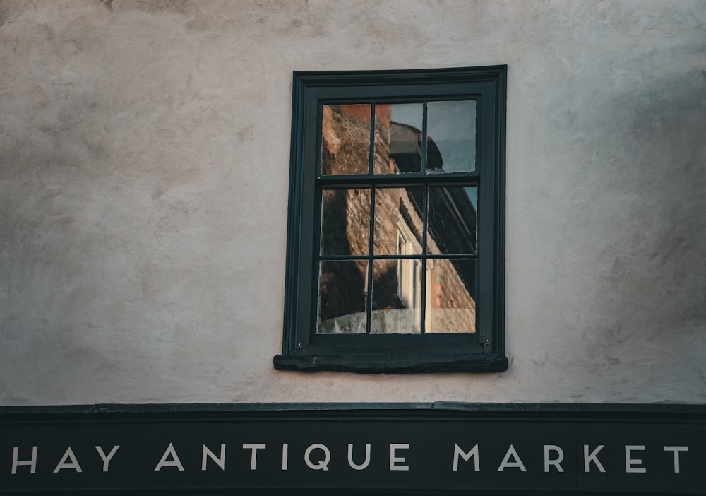 Ein Gebäude mit einem Fenster, das Heu Antiquitätenmarkt sagt