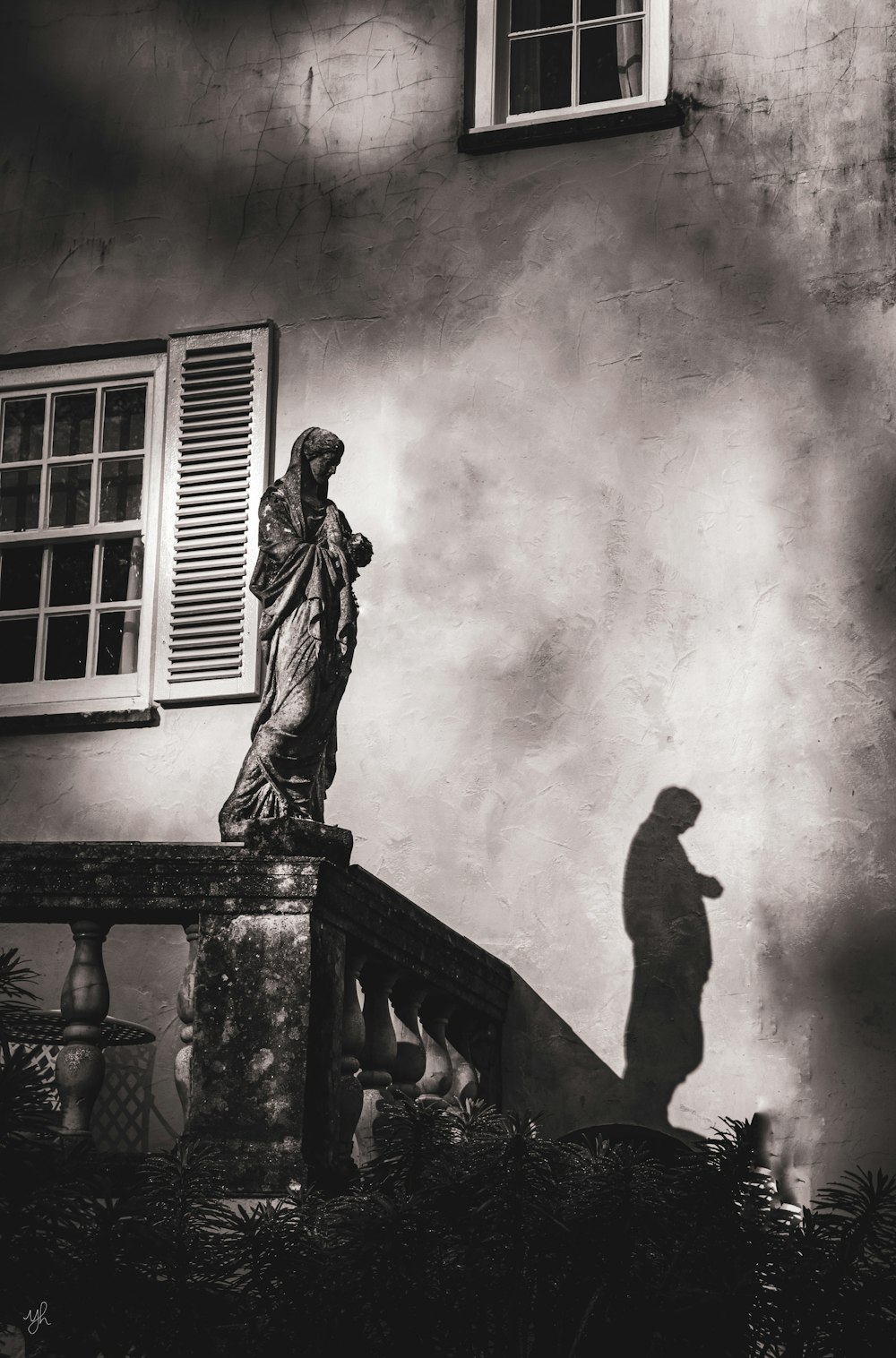 a black and white photo of a statue in front of a building