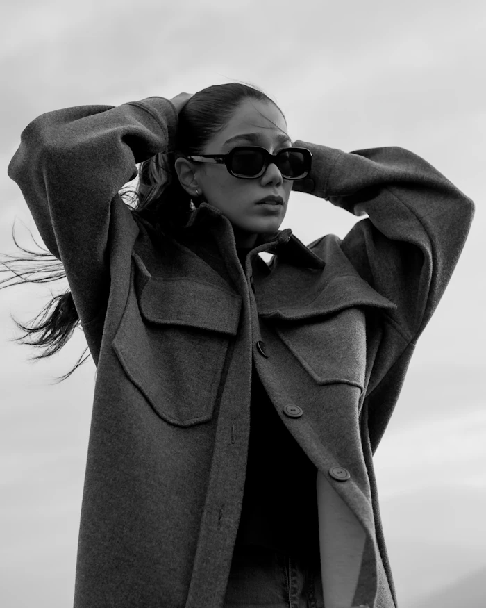 Black and white portrait of a woman in sunglasses and a wool overshirt