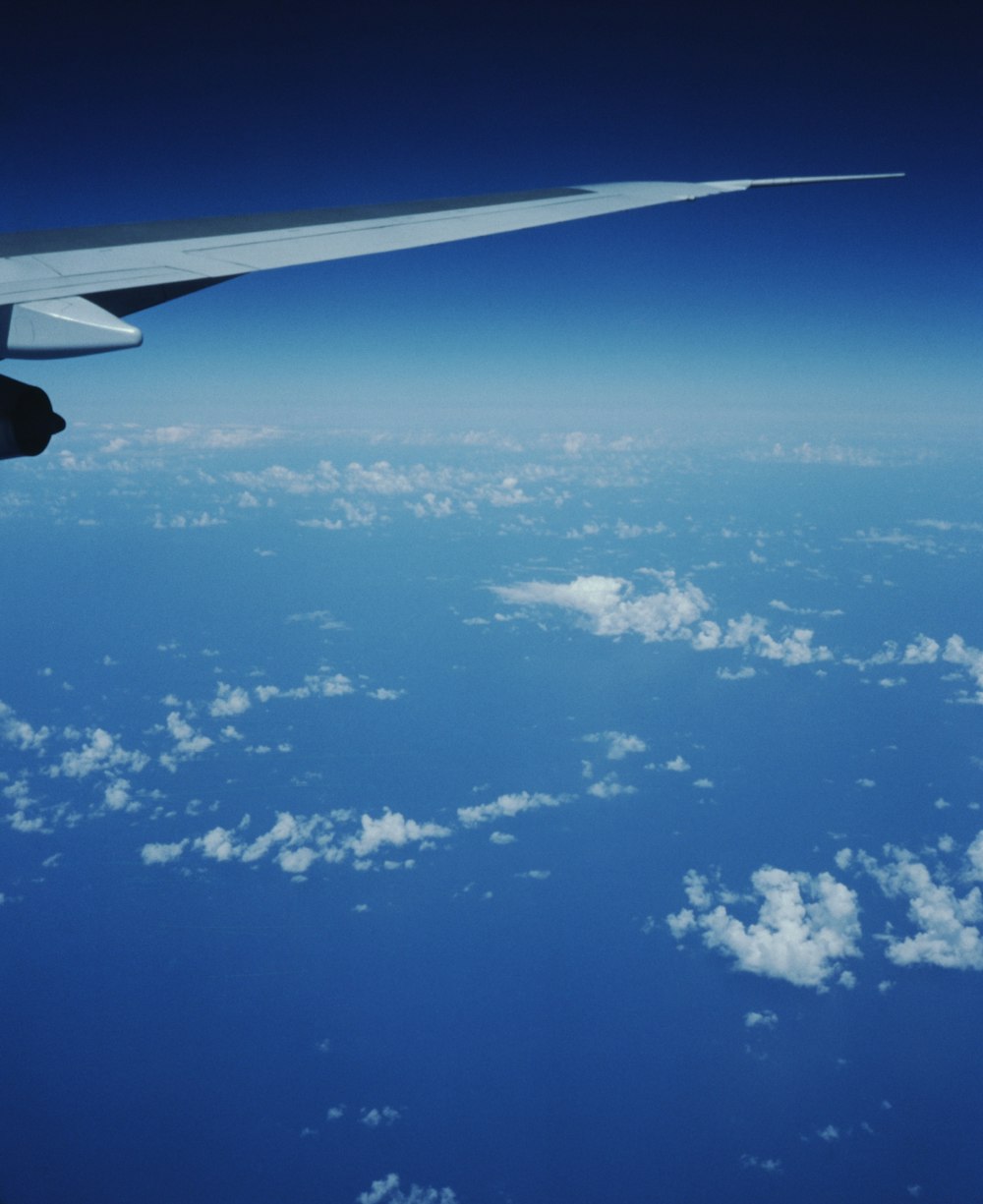 the wing of an airplane flying over the clouds