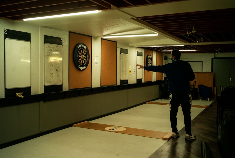 a man standing in a room with a skateboard