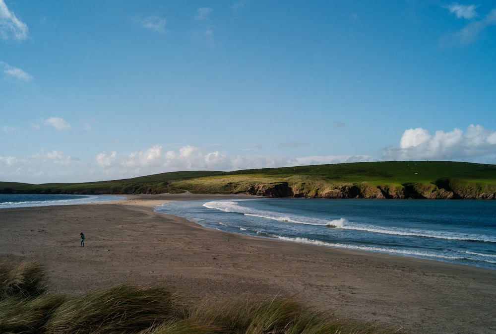 a person walking on a beach next to the ocean