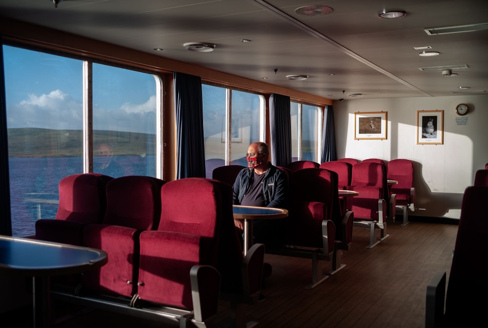 a man sitting in a red chair next to a window