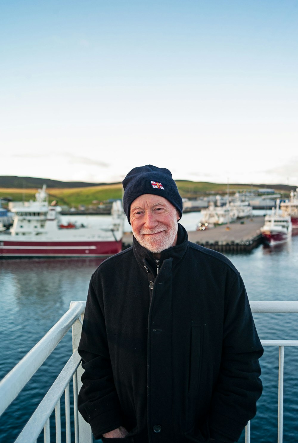 a man standing on a deck near a body of water