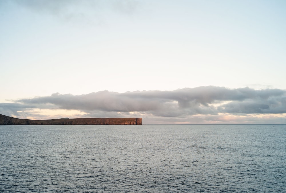 a large body of water sitting under a cloudy sky