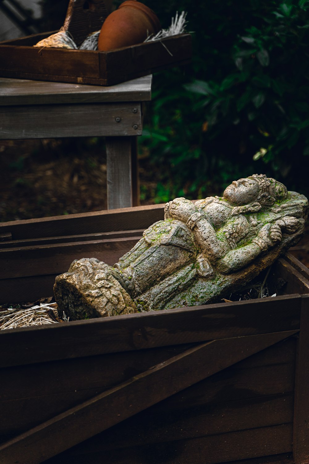 une boîte en bois avec une statue de grenouille dedans