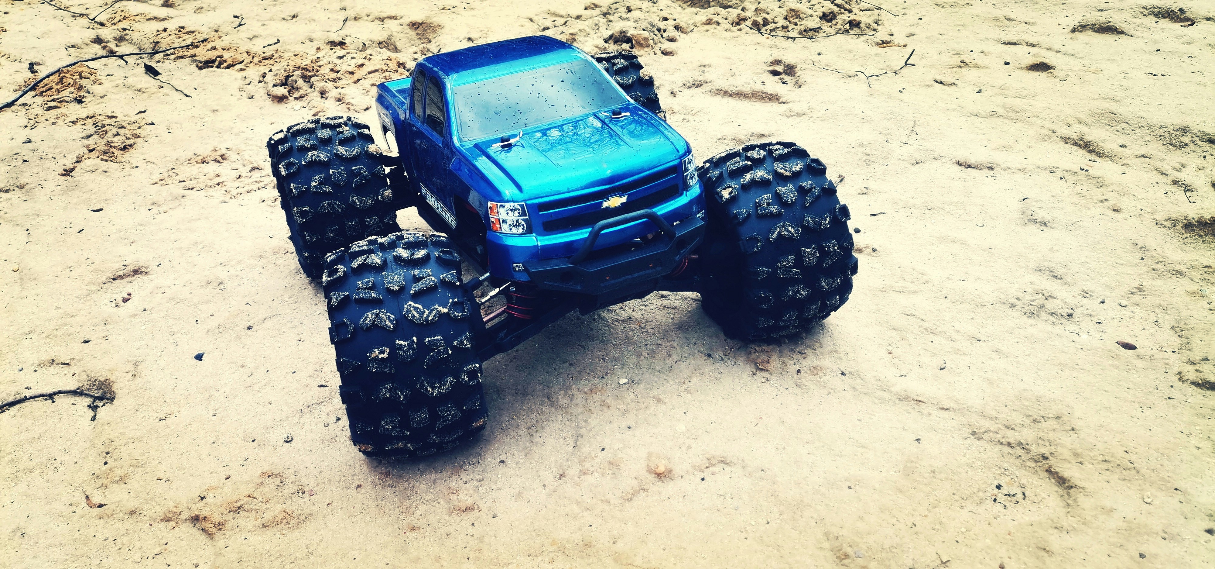 Heavy-duty off-road RC monster truck with large suspension system navigating rough terrain