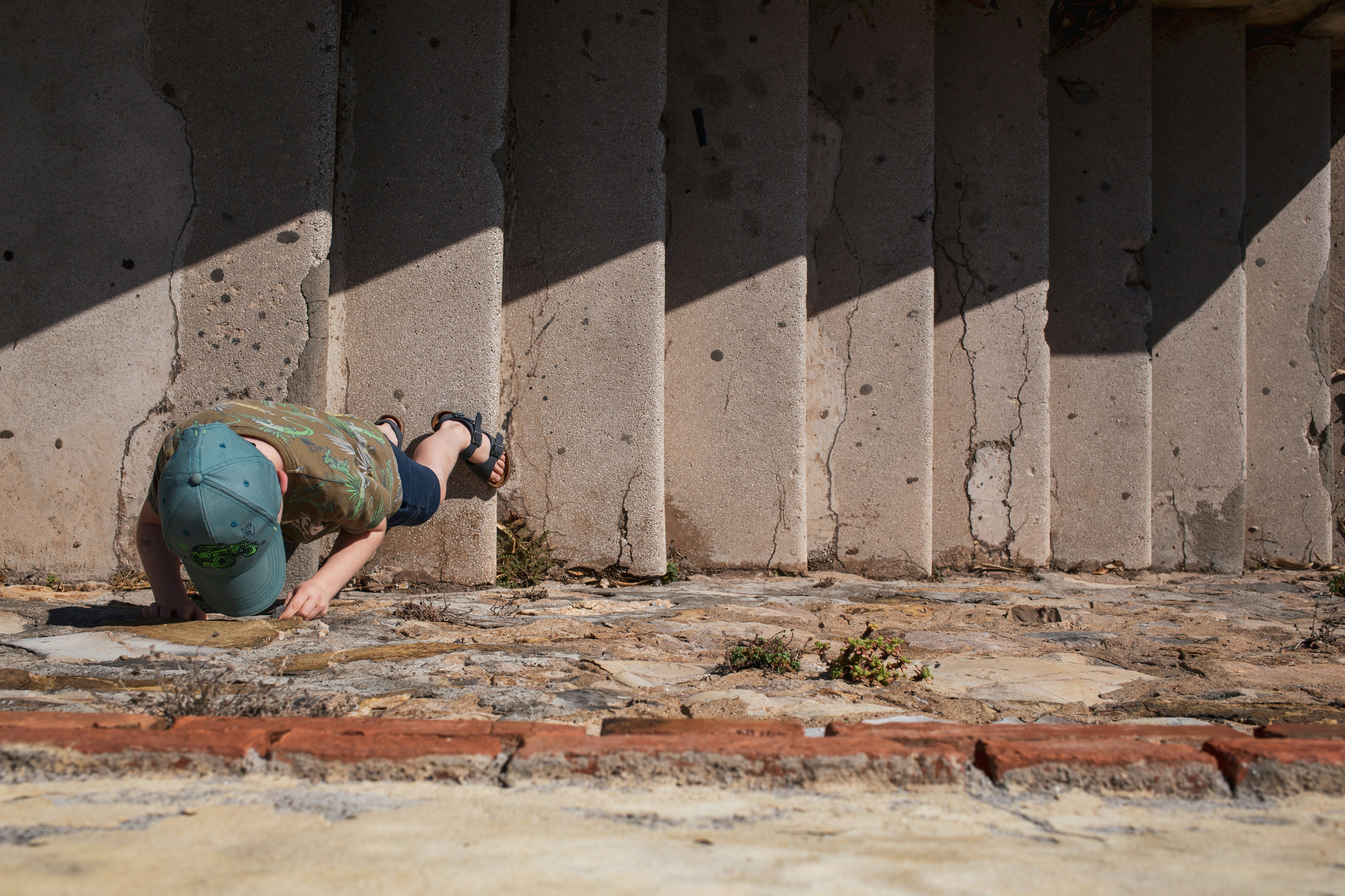 una persona arrodillada en el suelo frente a una pared