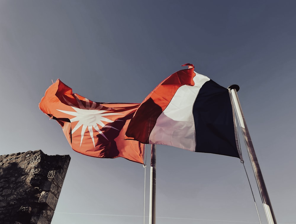 a flag flying in the wind on top of a mountain