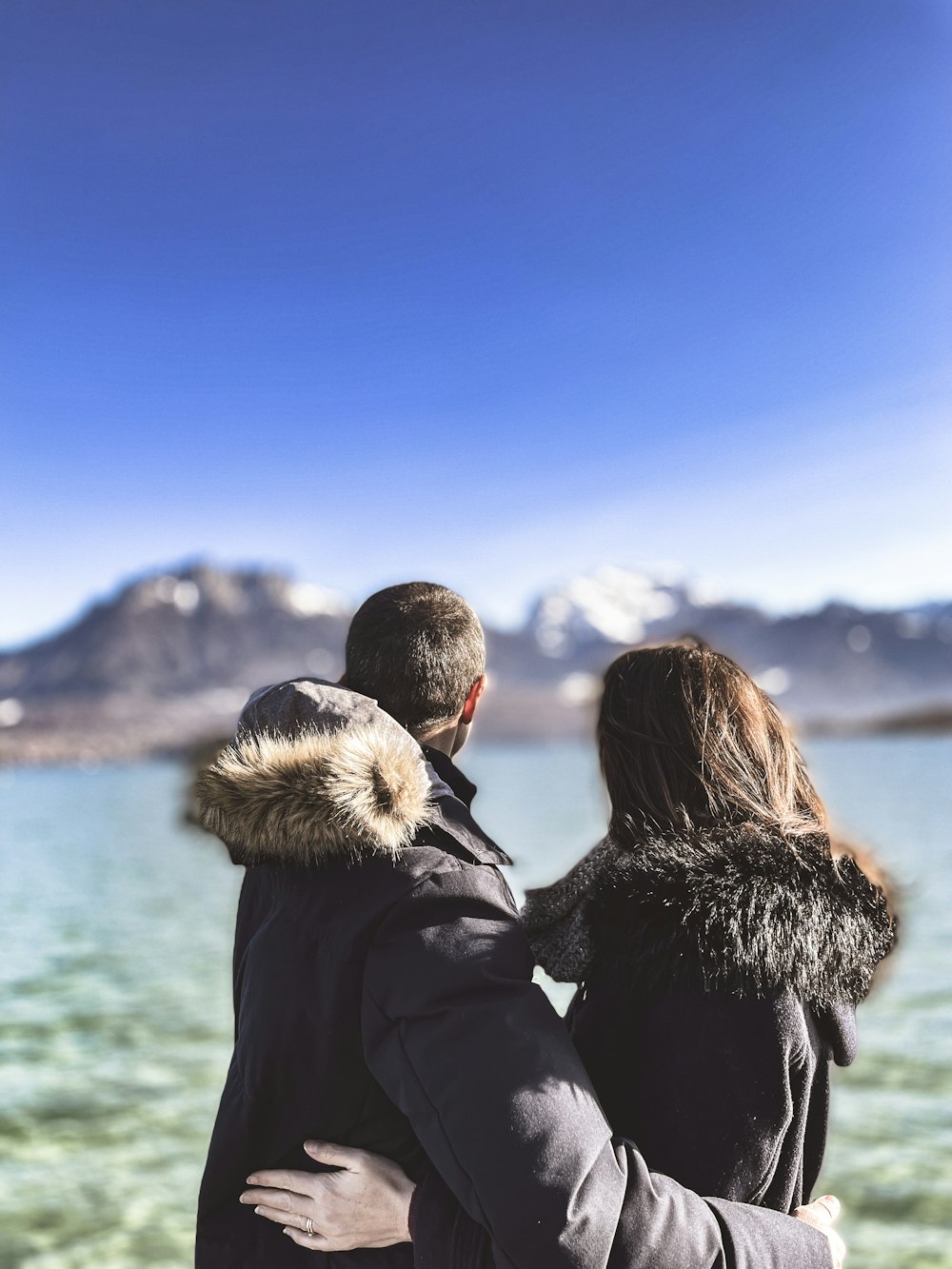 a man and a woman standing next to a body of water