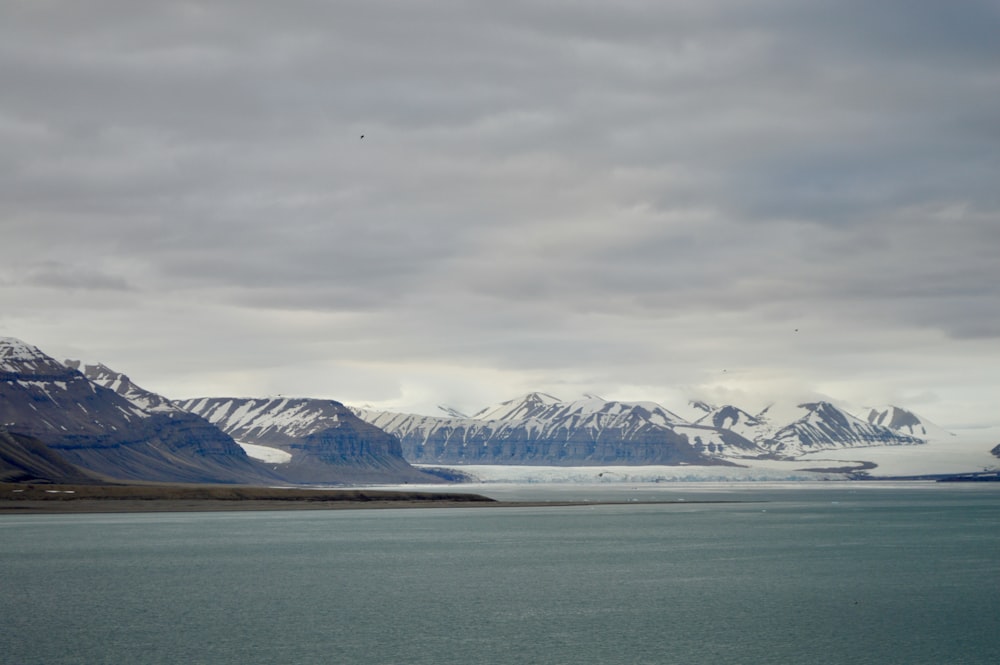 a large body of water with mountains in the background