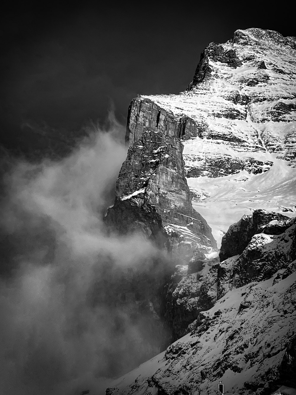 a black and white photo of a snowy mountain