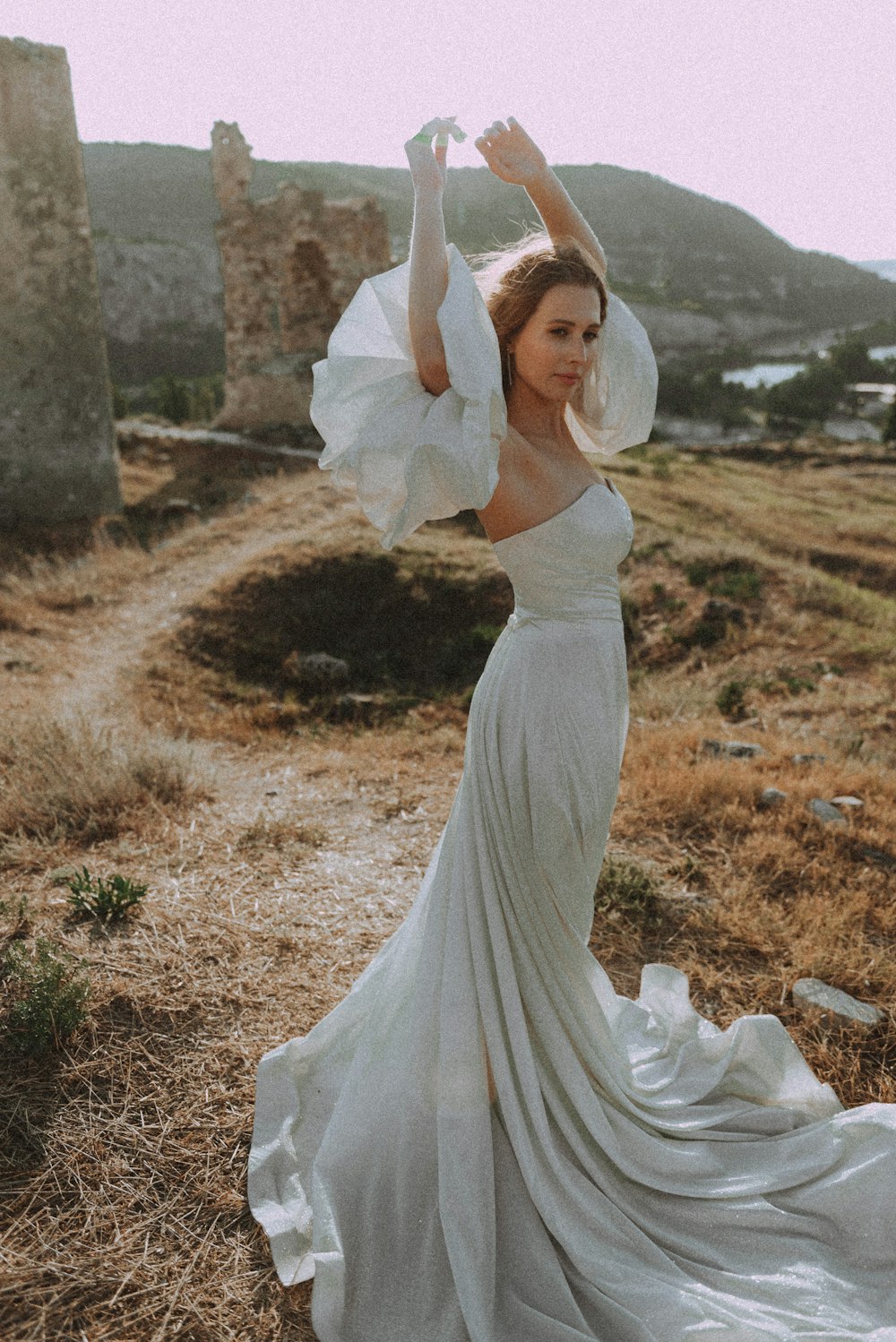 a woman in a white dress standing in a field