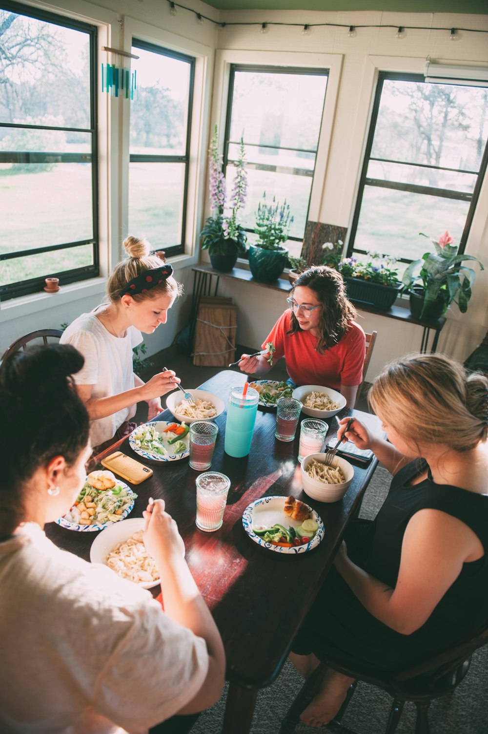 Foto zum Thema Eine gruppe von menschen, die um einen tisch sitzen und  essen essen – Kostenloses Bild zu Kleine gruppe auf Unsplash