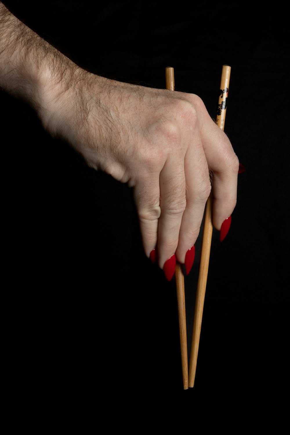 a person holding two chopsticks in their hand
