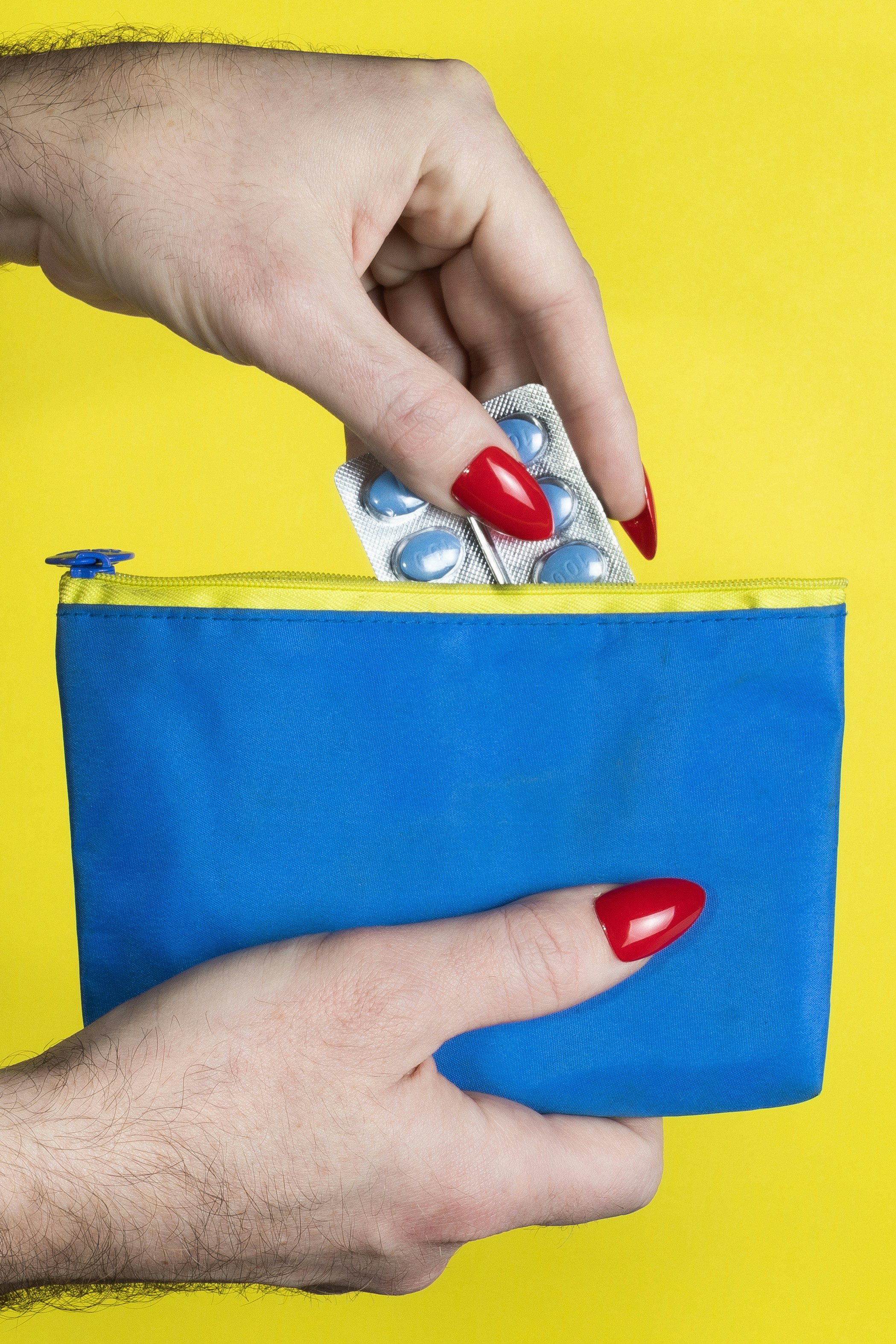 a woman's hand holding a blue purse