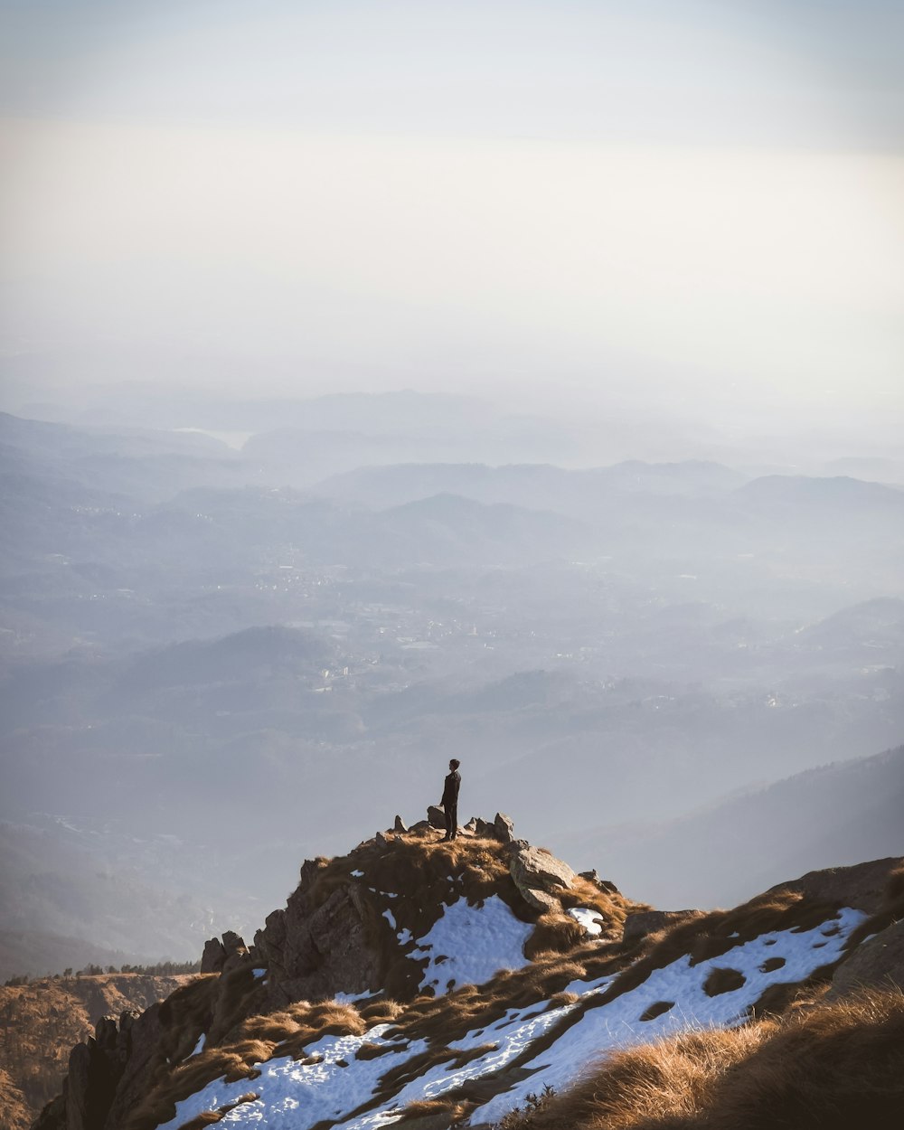 a couple of people standing on top of a snow covered mountain