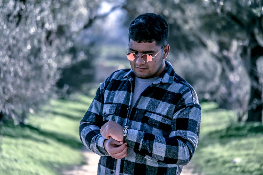 a man in a plaid shirt looking at his cell phone